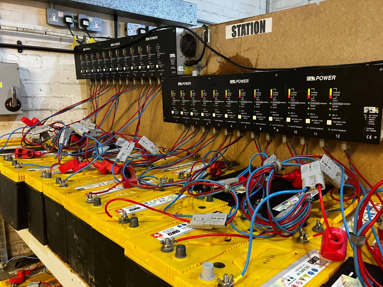 line up of lead acid batteries on charging bench